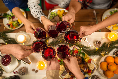节日庆祝亲密的朋友家里吃诞晚餐,喝红酒碰杯亲密的朋友用葡萄酒庆祝诞节图片
