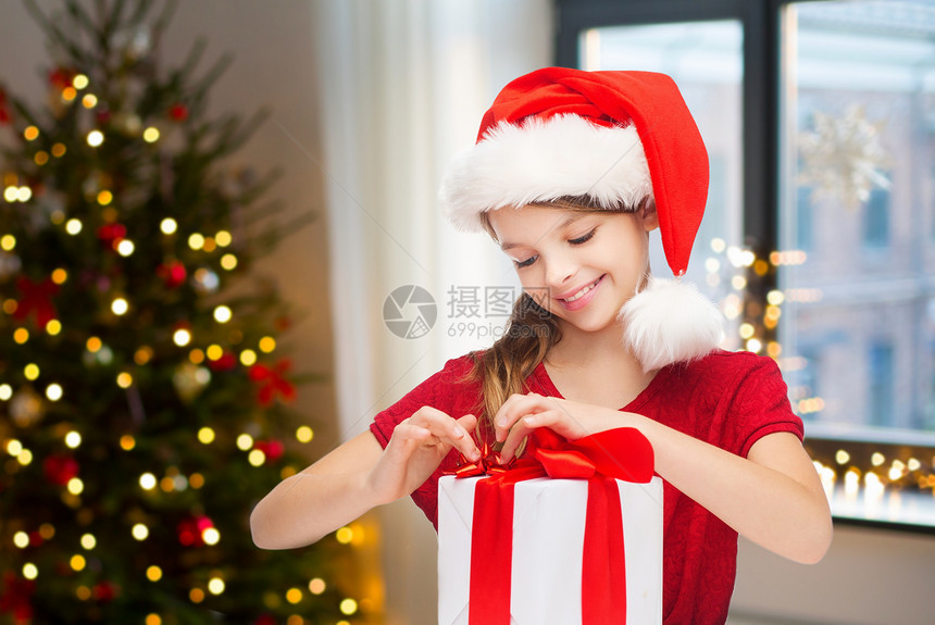 假期童的快乐的女孩与礼品盒家里的房间与诞树背景家里诞礼物的快乐女孩图片