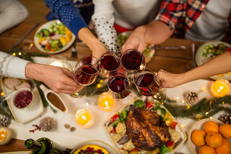 节日庆祝亲密的朋友家里吃诞晚餐,喝红酒碰杯亲密的朋友用葡萄酒庆祝诞节图片