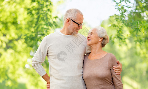 老人的幸福的老夫妇拥抱绿色的自然背景老夫妇拥抱自然背景图片