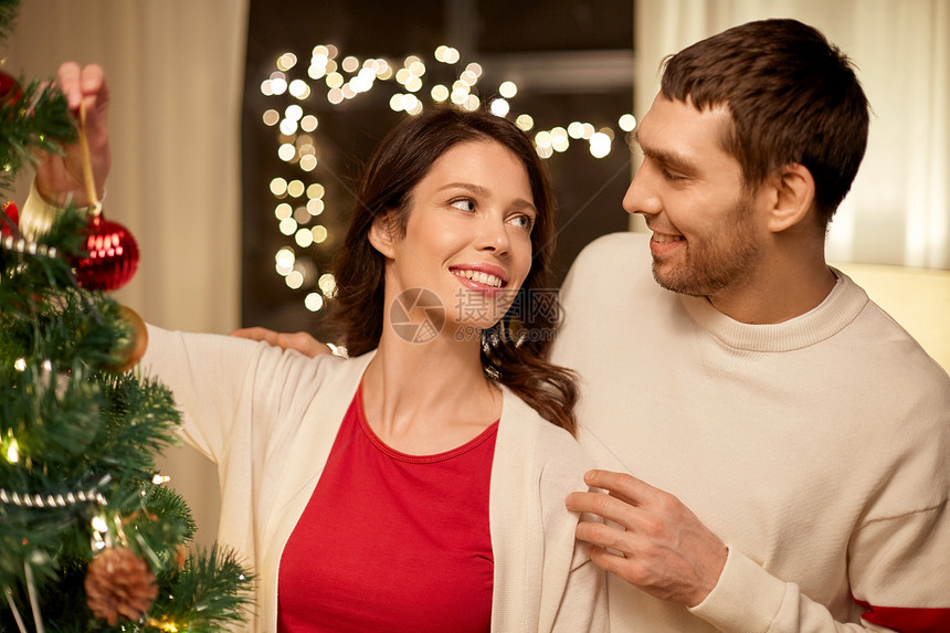 寒假人们的幸福的夫妇家里装饰诞树幸福的夫妇家里装饰诞树图片