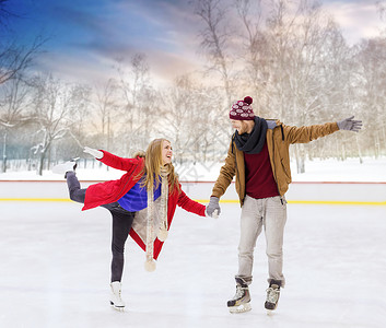 人,友谊,运动休闲的快乐的夫妇牵手户外溜冰场幸福的夫妇牵手户外溜冰场图片