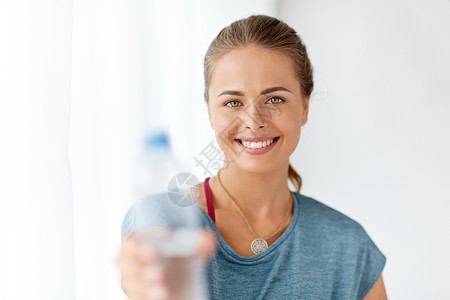 健身健康的生活方式微笑的轻女人展示瓶水快乐的女人展示了瓶水图片