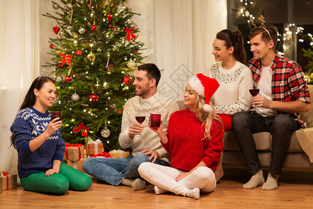 庆祝节日的快乐的朋友戴着眼镜,家里聚会庆祝诞节,喝红酒朋友们庆祝诞节喝酒图片