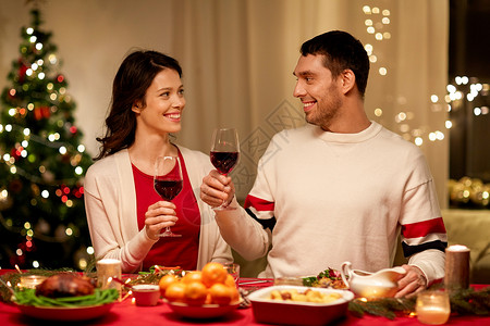节日,家庭庆祝快乐的夫妇家里吃诞晚餐喝红酒快乐的夫妇诞晚餐上喝红酒图片