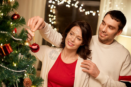 寒假人们的幸福的夫妇家里装饰诞树幸福的夫妇家里装饰诞树图片