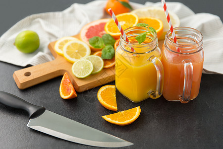 黑色刀食物,健康饮食素食梅森罐杯与果汁柑橘类水果石板桌梅森罐杯,桌上果汁水果背景