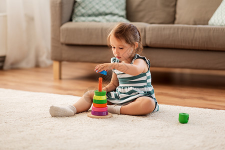 童人的快乐的三岁女婴玩玩具块家快乐的女婴家里玩玩具积木背景图片