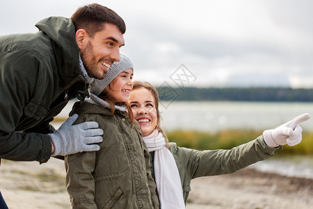 家庭,休闲人的快乐的母亲,父亲小女儿秋天的海滩秋天海滩上的幸福家庭图片