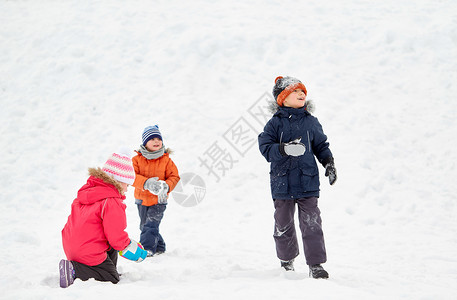 丢雪球女孩童,休闲季节的群快乐的孩子穿着冬天的衣服户外玩耍快乐的小孩子冬天户外玩耍背景