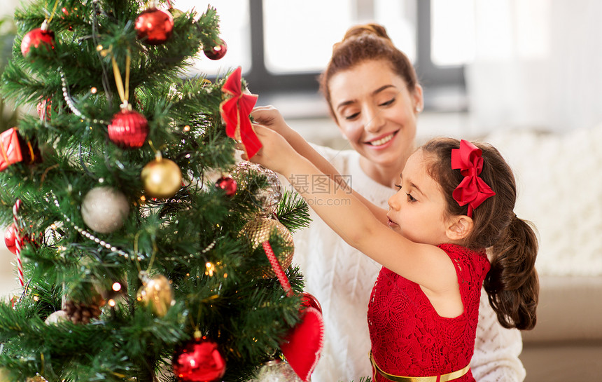 家庭,寒假人们的快乐的母亲小女儿家里装饰诞树幸福的家庭家里装饰诞树图片