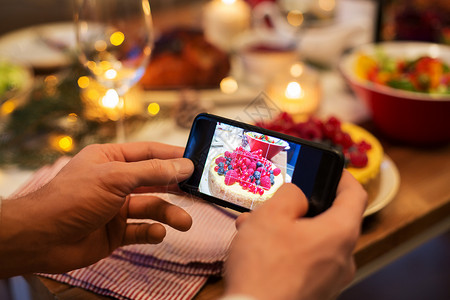 食物技术假日诞节晚餐时,用智能手机近距离拍摄蛋糕诞节晚餐时双手拍照食物图片