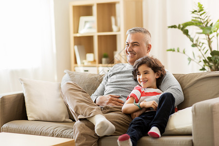 家庭父亲人的快乐的父亲小儿子坐家里的沙发上看电视快乐的父亲小儿子家图片