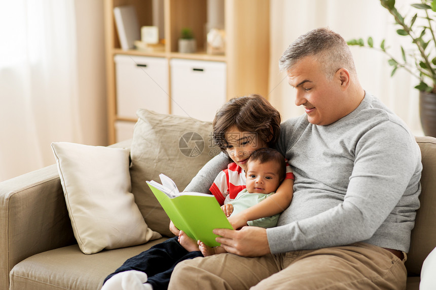 家庭,父亲人的快乐的父亲与青春期前小儿子家阅读书籍快乐的父亲儿子家看书图片
