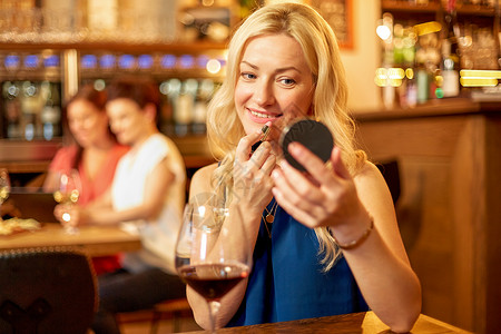 美丽,化妆生活方式的酒吧餐厅用口红镜子的快乐女人口红的女人酒吧化妆图片