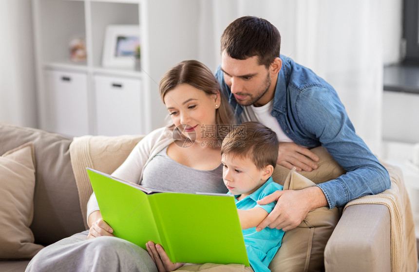 人们家庭的快乐的母亲,父亲小儿子家沙发上看书家快乐的家庭读物图片