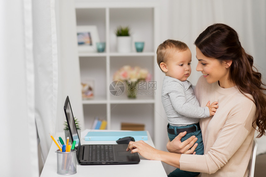 母亲,多任务,家庭人的快乐的母亲与婴儿笔记本电脑家里工作快乐的母亲带着孩子笔记本电脑家工作图片