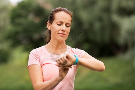 运动,技术人的妇女与健身跟踪器夏季公园夏天公园健身追踪器的女人图片