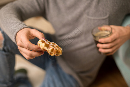 食物人的接近男人家里吃华夫饼咖啡家吃华夫饼咖啡的男人图片