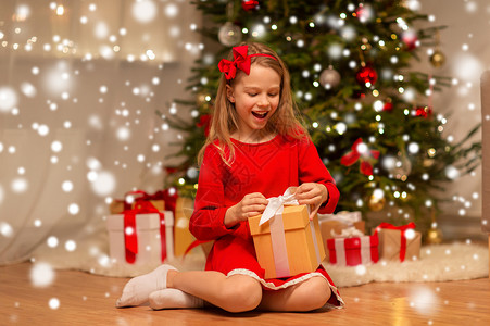 诞节,假日童的微笑的女孩穿着红色连衣裙,家里礼品盒微笑的女孩带着诞礼物家图片