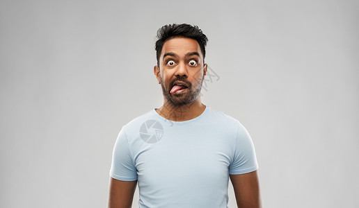 表情,粗鲁人的印度男人脸他的舌头灰色的背景印度男人鬼脸,露出舌头图片