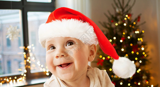 童,假期人的快乐的小男孩诞帽诞树灯光背景诞节戴诞帽的快乐小男孩图片