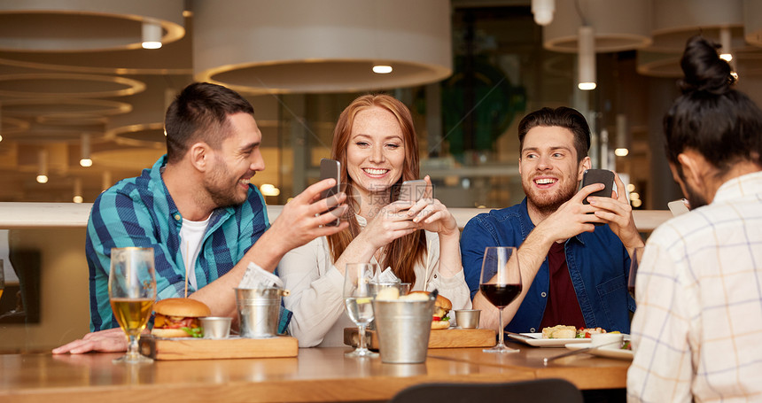 休闲,技术,生活方式人们的快乐的朋友与智能手机餐厅就餐餐馆用智能手机的快乐朋友图片