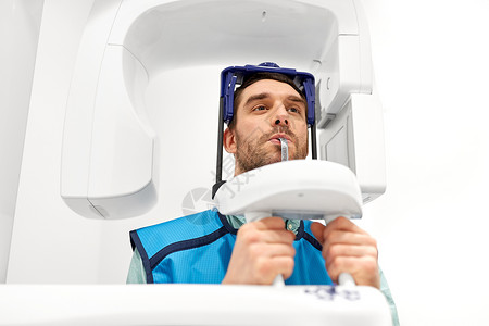 医学,牙科医疗男患者全景X射线扫描程序牙科诊所牙科诊所进行X线扫描的病人背景图片
