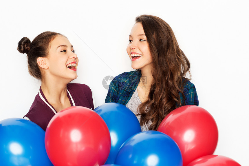 微笑的漂亮少女拿着红色蓝色氦气球图片