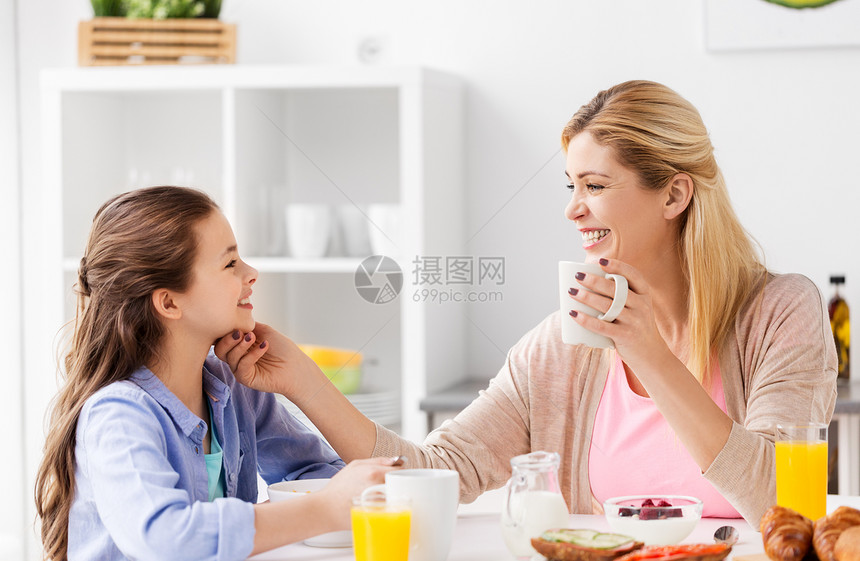 食物,健康饮食,家庭人的快乐的母亲女儿家里的厨房吃早餐快乐的母亲女儿家吃早餐图片