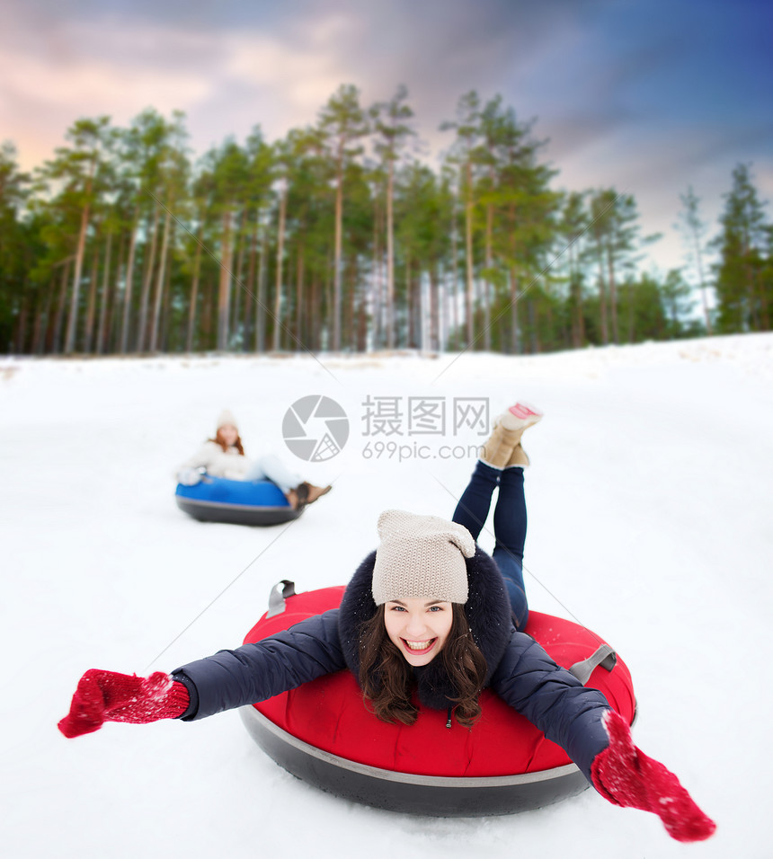 冬季,休闲娱乐活动的快乐的十几岁女孩滑下山的雪管自然背景快乐的少女雪管上滑下山图片