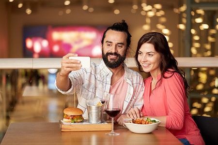 吃饭照片素材休闲,技术人的快乐的夫妇餐厅吃午饭用智能手机自拍夫妇餐厅用智能手机自拍背景