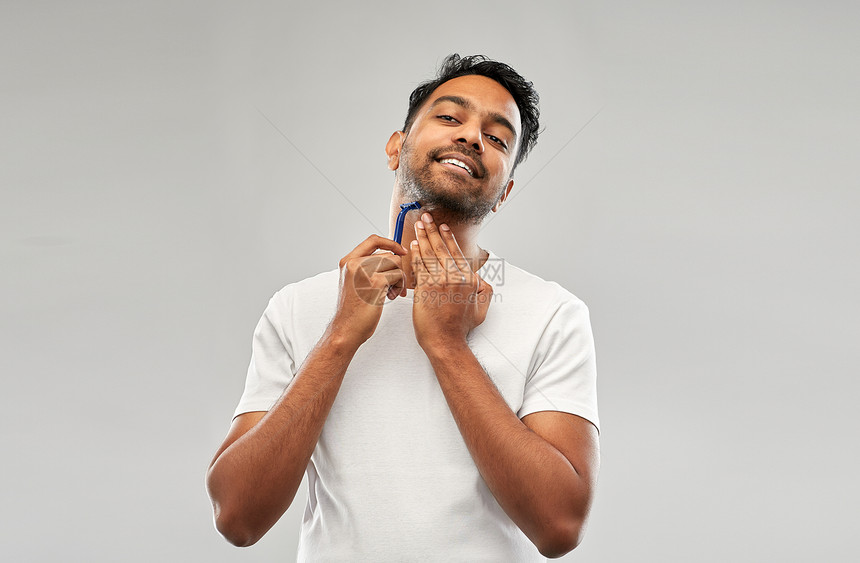 美容人的轻的印度男子剃须胡须与手动剃须刀刀片灰色背景印度男人用剃须刀刮胡子图片