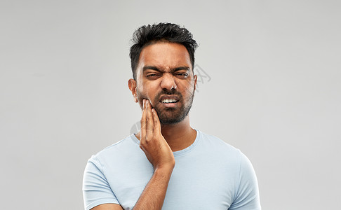 人,牙科健康问题的印度男子患牙痛的灰色背景印度男人牙疼图片