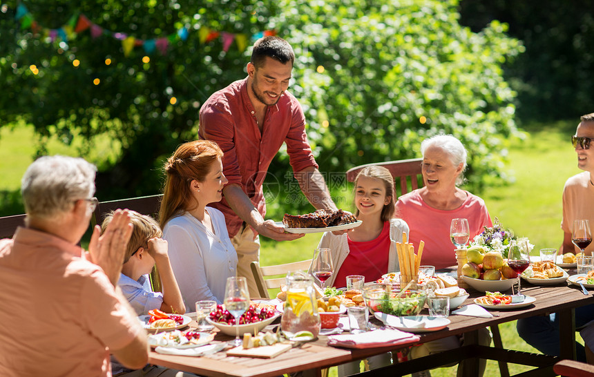 休闲,假日人们的快乐的家庭夏季花园举行节日晚餐烧烤聚会快乐的家庭吃晚饭夏季花园派图片