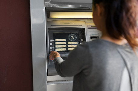 ATM取钱金融,加密货币技术妇女ATM机与比特币图标屏幕上女人ATM机与比特币图标屏幕上设计图片