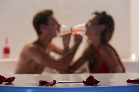 浪漫的轻夫妇按摩浴缸里喝香槟图片