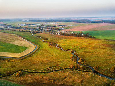 秋晚乡村鸟瞰与河流,小溪,村庄,道路农业领域的背景五颜六色的日落秋景图片