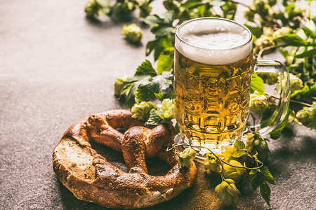 啤酒杯椒盐卷饼,葡萄藤啤酒花锥德国巴伐利亚风格图片