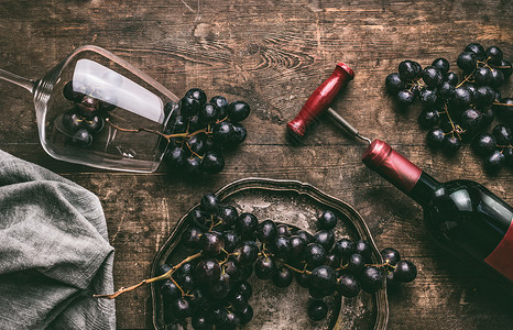 红酒还活着酒杯与瓶子,开瓶器红色葡萄集群木制乡村背景,顶部视图背景图片