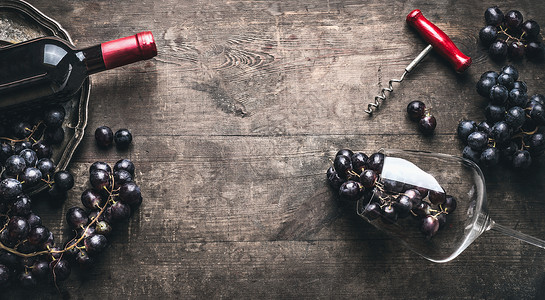 红酒背景与瓶子瓶塞,葡萄酒杯黑暗的老式木制,顶部视图,框架背景图片