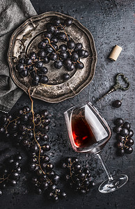 红酒与璃,葡萄旧盘子老式瓶塞螺丝黑暗的桌子背景,顶部视图背景图片