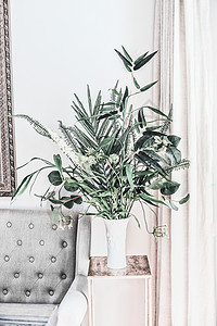 现代静物与室内植物花瓶沙发,正视图竹与热带树叶树枝排列家里的白色墙壁上图片