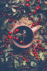 杯带红色浆果落叶的秋茶,顶部景色秋天的静物图片