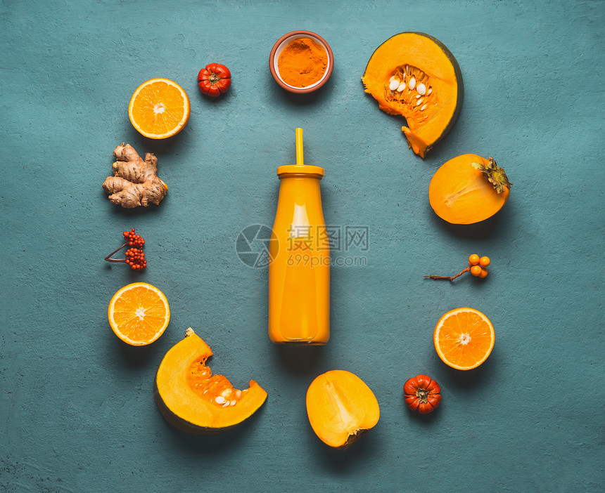 橙色冰沙成分南瓜,柿子,橙色水果,生姜姜黄粉围绕瓶与健康的活力冰沙为寒冷的季节,顶部视图与为您的图片