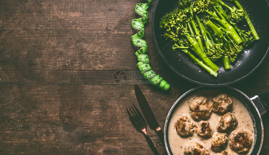 低卡比节食餐与肉球,漂白西兰花烹饪锅,餐具测量磁带木桌背景,顶部视图与健康减肥饮食食品图片
