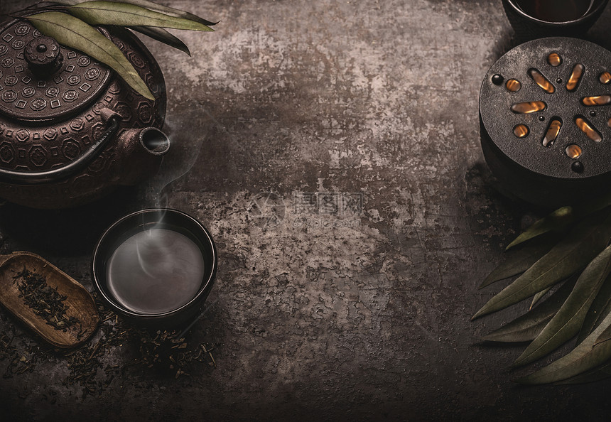 深色亚洲茶背景,黑色铁茶壶绿茶杯为您的正宗的复古风格传统的茶道安排图片