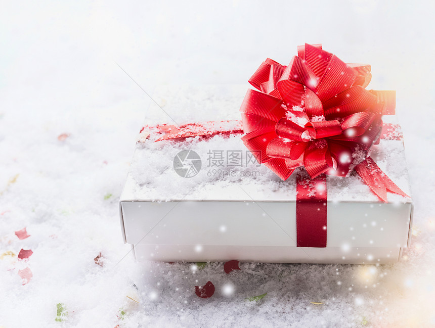 白色礼品盒,红结雪地上,波克降雪您的模板,邀请,优惠券,销售祝贺图片