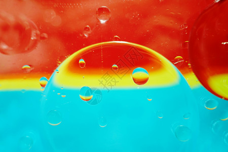 个美丽充满活力的观油泡水上与黄色,蓝色红色条纹纹理背景图案与老式过滤器图片