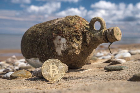 比特币的宝藏背景下的瓶子与钱海滩上图片